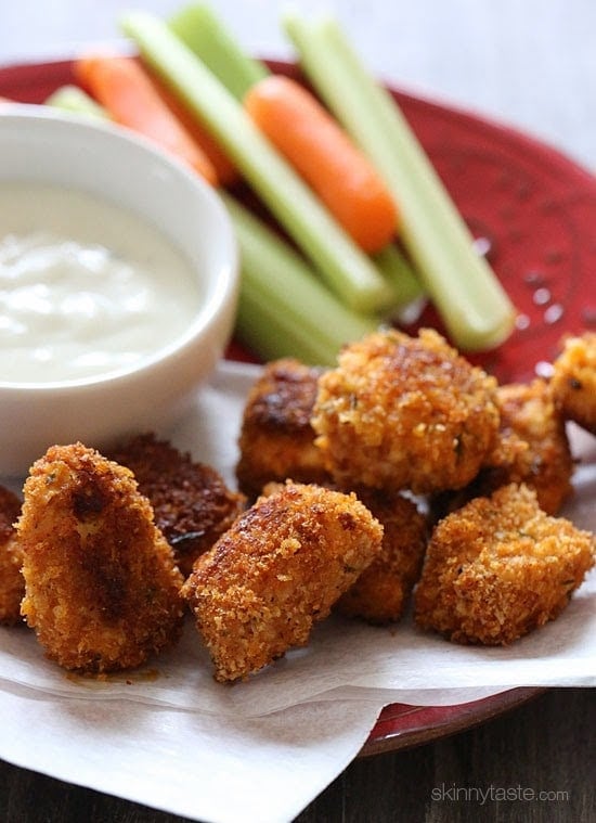 Baked Buffalo Chicken Nuggets A plate of crispy baked buffalo chicken nuggets with carrots and celery sticks and creamy dipping sauce