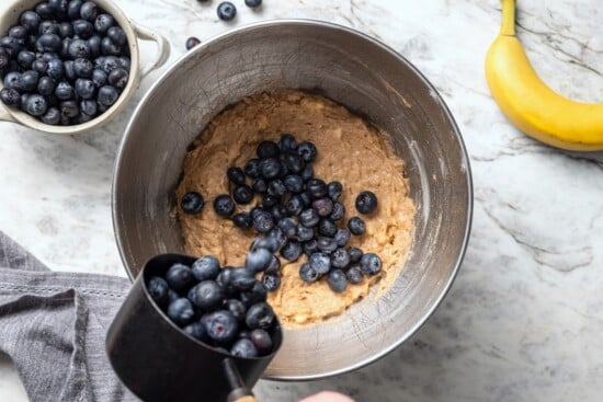 This blueberry banana bread is a lighter twist on a classic that’s perfect for breakfast, snacking, or anytime you have ripe bananas to use! Adding blueberries to banana bread batter.