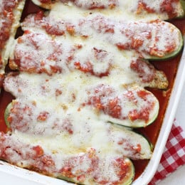 Sausage stuffed zucchini boats in casserole dish.
