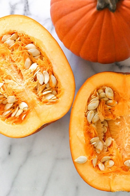 These Spicy Pumpkin Seeds are a fun twist on roasted pumpkin seeds. They make a tasty, filling snack on their own and a great salad topper. A small pumpkin cut in half to show the seeds