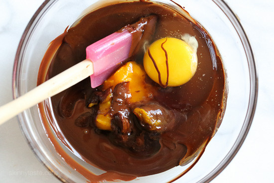 Made with 6 ingredients, this Flourless Chocolate Cake is a rich dessert guaranteed to satisfy any chocolate craving. Ready in 20 minutes! Eggs and pumpkin being stirred into melted chocolate