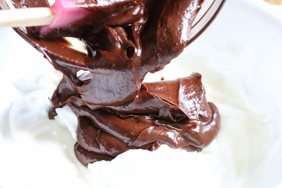 Made with 6 ingredients, this Flourless Chocolate Cake is a rich dessert guaranteed to satisfy any chocolate craving. Ready in 20 minutes! Chocolate cake batter being folded into whipped egg whites