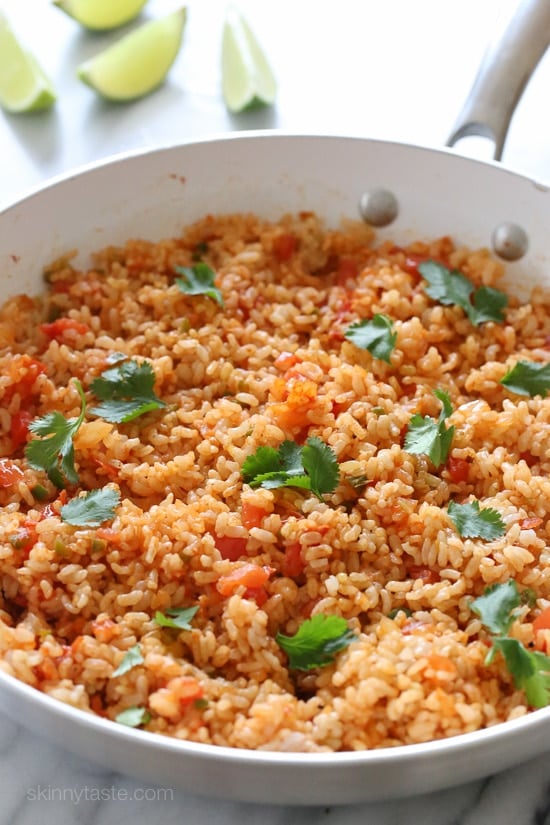 Want to know how to cook perfect brown rice? This easy, foolproof brown rice recipe will give you perfect rice that is never sticky. A pan filled with fluffy Mexican brown rice.