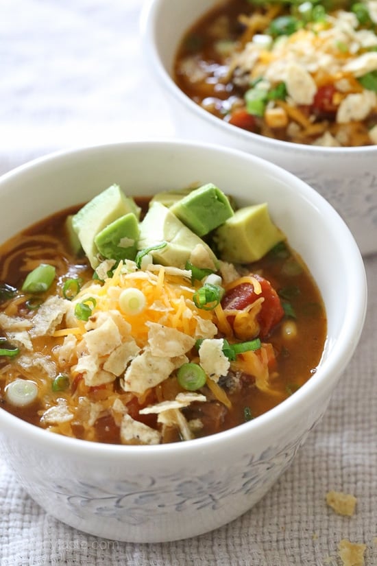 This Vegetarian Pumpkin Chili is loaded with pumpkin puree, veggies, beans, and a homemade spice blend. Hearty, filling, and oh-so-tasty! A bowl of pumpkin chili topped with shredded cheese and avocado