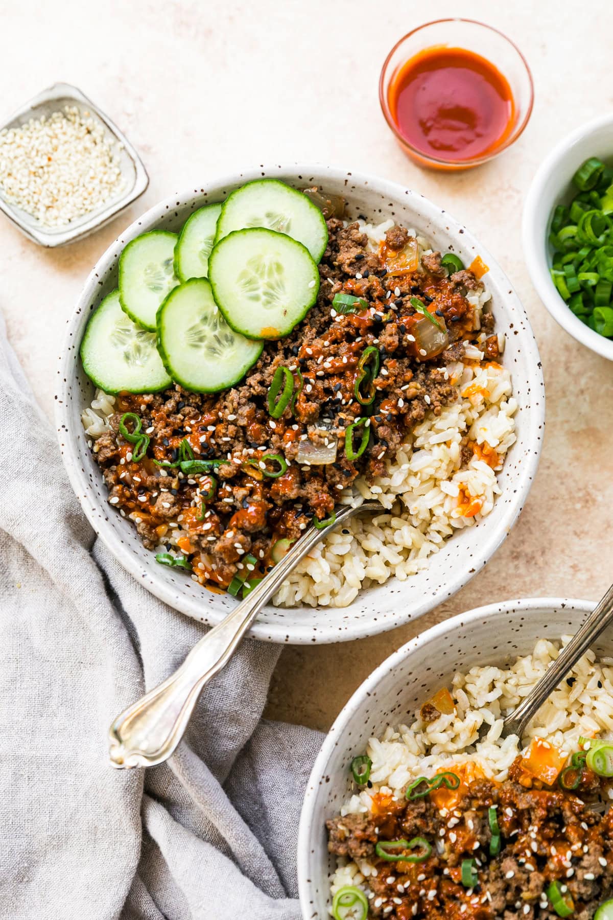 An easy and delicious Korean beef recipe is made with ground beef, served over rice with cucumbers and gochujang sauce. Homemade Korean beef served in a white bowl with rice and cucumber slices.