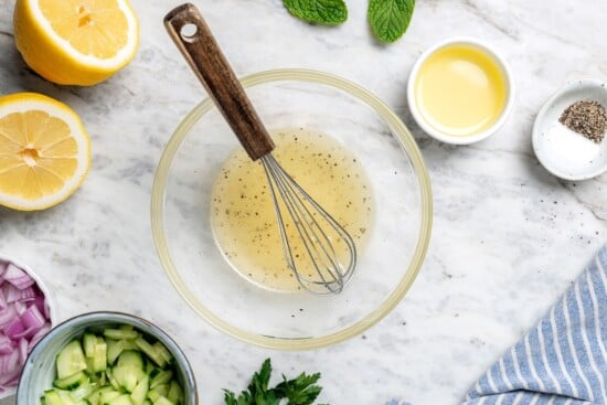 This easy garbanzo bean Mediterranean salad is fresh, simple, and full of flavor, made with minimal prep and wholesome ingredients. Lemon dressing in bowl with small whisk.