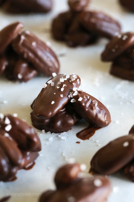 These easy 5-ingredient nut clusters are made with almonds, pecans and walnuts dipped in dark melted chocolate and finished with a touch of sea salt for the tastiest and healthy-ish Holiday treat!
