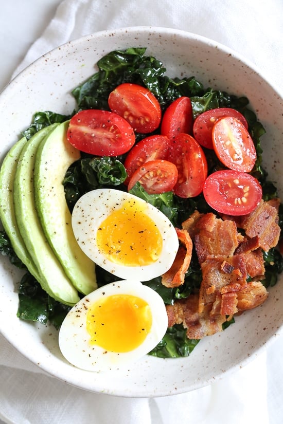 Salad for breakfast? Yes!! This Breakfast BLT Salad can be eaten anytime of the day really, but eggs and bacon served over this simple massaged kale salad with avocado and tomatoes is a delicious, savory, healthy breakfast idea. 
