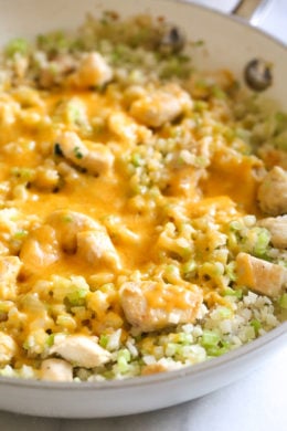 Skillet Cheesy Chicken and Veggie "Rice" made with riced broccoli and cauliflower, sauteed chicken and cheddar cheese. It's so fast and easy to make!