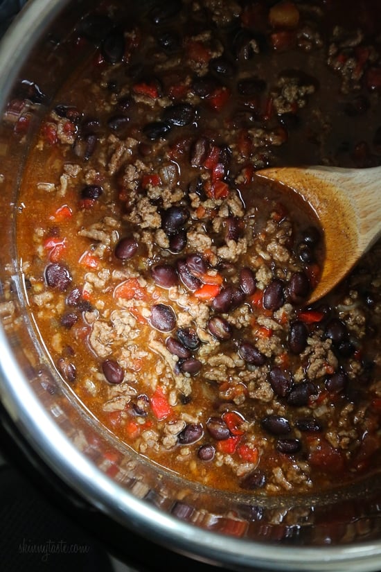 Hearty, filling, and ready in an hour, this is truly the best chili recipe! Made with beans, beef, and a blend of spices. A wooden spoon stirring beef chili