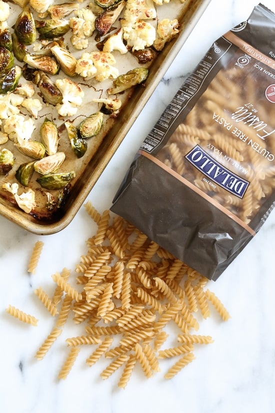 Creamy, Pumpkin Mac and Cheese with Roasted Veggies is comfort food, in a bowl! Made with pumpkin puree, roasted cauliflower and Brussels sprouts.