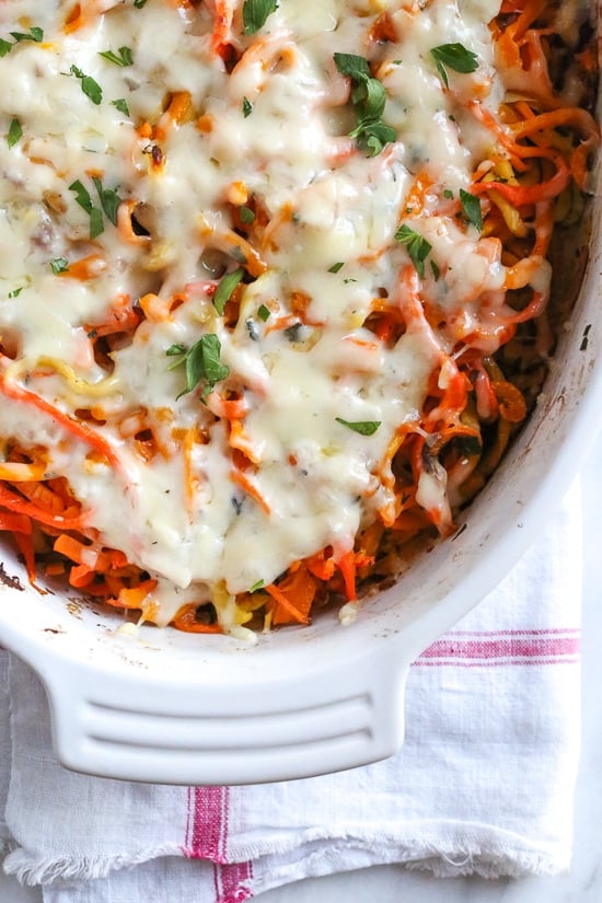 Spiralized Winter Veggie Gratin is the perfect holiday side dish! Made with spiralized vegetable gratin is made with sweet potatoes, butternut squash, carrots, and parsnips and topped with a white sauce and Gruyere cheese.