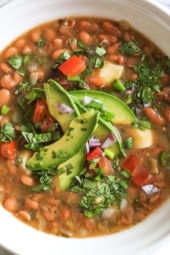 Mexican Pinto Beans, Frijoles Con Todo are made from scratch in the pressure cooker with dry pinto beans, onions, chile, jalapeno, tomatoes, cilantro, avocado and my favorite part, the queso! These soupy beans are not spicy, and can be served as a soup or as a side dish over rice or with tortillas.