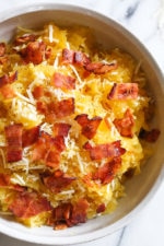 Roasted spaghetti squash with bacon and Parmesan cheese is a great way to top spaghetti squash for an easy, tasty side dish. Although there are several methods to cook spaghetti squash, my favorite way to make it is roasted. To roast the squash, I cut it on half lengthwise, remove the seeds and cook it cut down for about one hour.