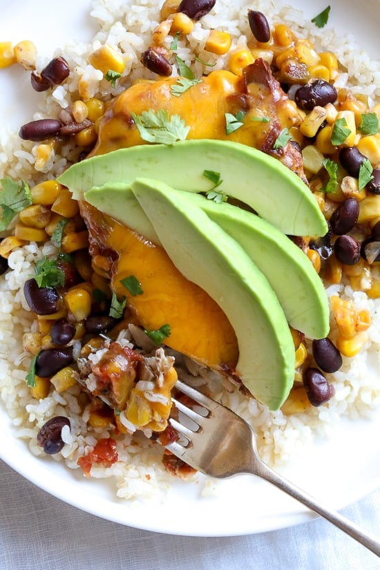 This EASY Slow Cooker Chicken dish is cheesy and delicious, made with boneless chicken breast, black beans, corn and salsa topped with melted cheddar cheese. YUM!