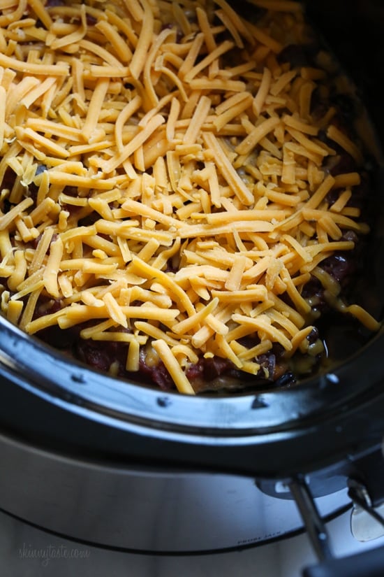 This EASY Slow Cooker Chicken dish is cheesy and delicious, made with boneless chicken breast, black beans, corn and salsa topped with melted cheddar cheese. YUM!