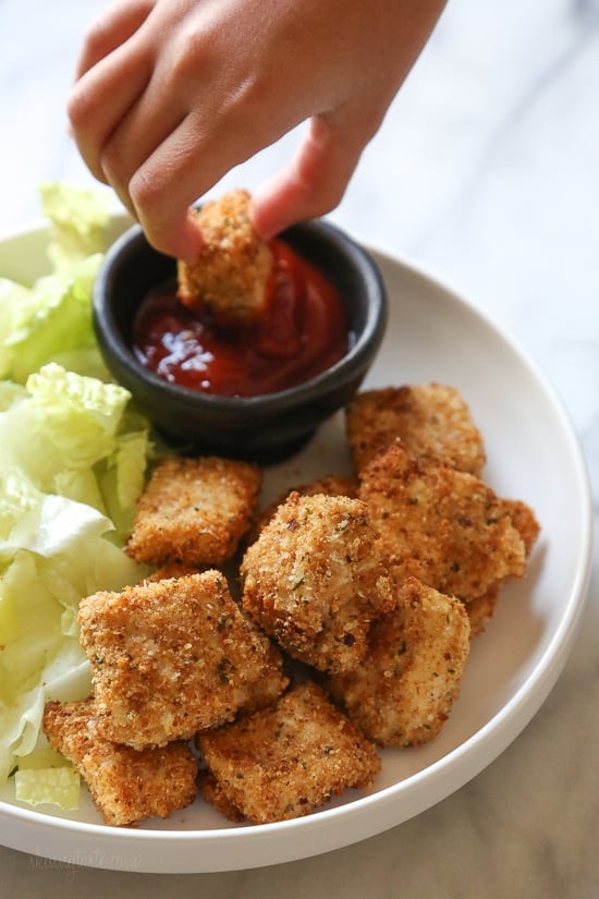 dipping chicken nuggets into ketchup