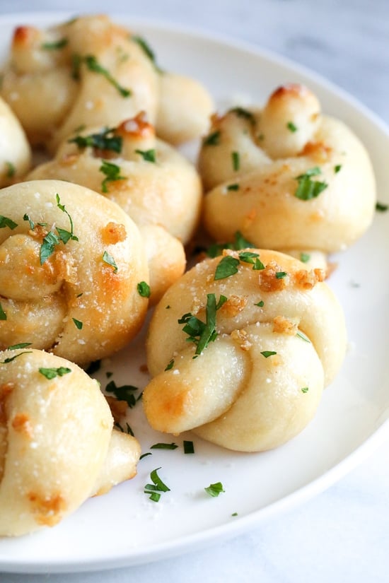 These soft, garlicky knots taste just like your favorite pizzeria’s garlic knots, but made from scratch using my easy yeast-free bagel dough recipe (just flour, Greek yogurt, baking powder and salt).