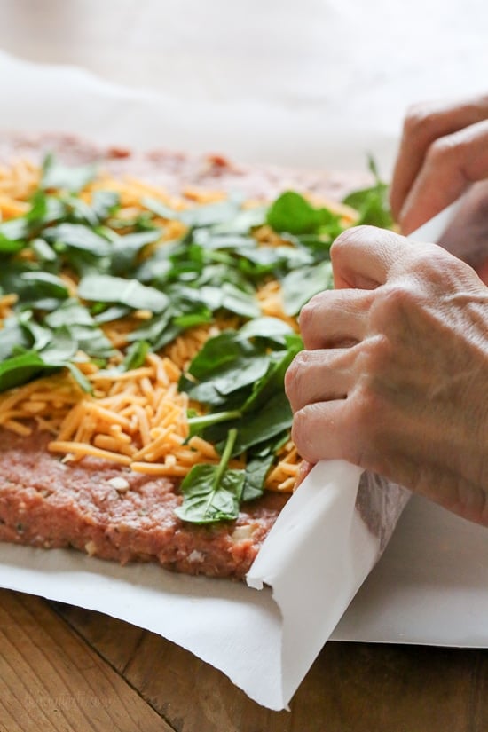 The best tasting, moist turkey meatloaf stuffed with cheddar cheese, spinach and rolled, jelly roll style topped with a ketchup based glaze.