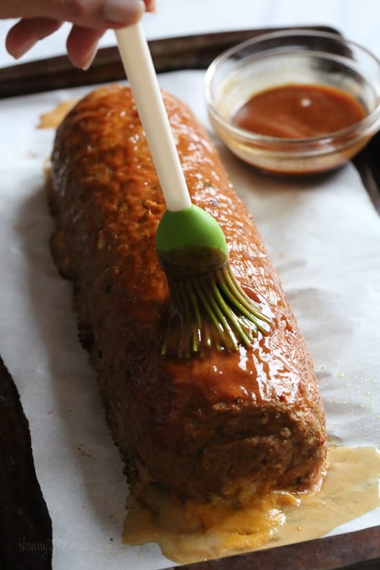 The best tasting, moist turkey meatloaf stuffed with cheddar cheese, spinach and rolled, jelly roll style topped with a ketchup based glaze.