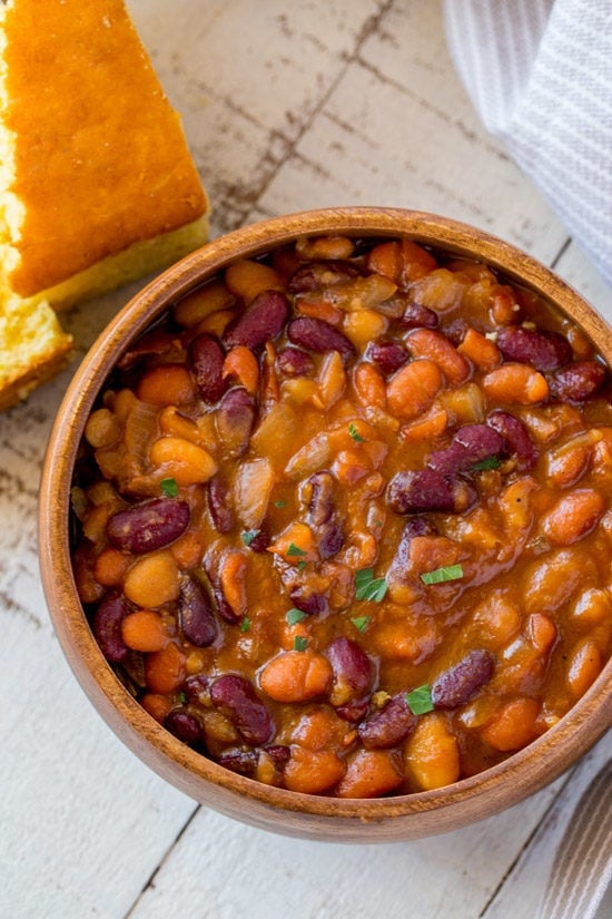 Instant Pot Brown Sugar Baked Beans are a quick and easy summer side dish thanks to the instant pot with all the hearty, filling, baked bean flavors you love. Instant Pot Baked Beans in bowl with cornbread