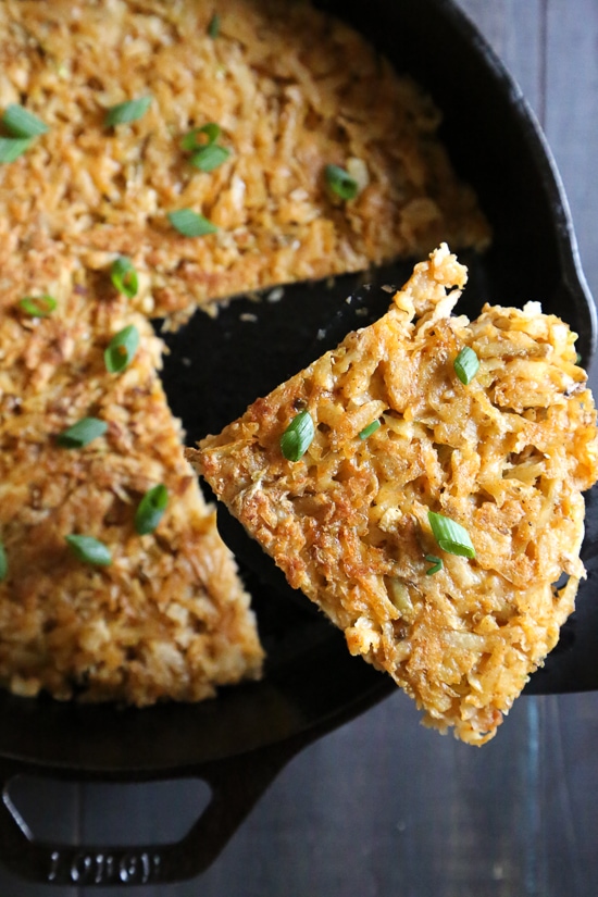Here's how to make hash browns that are beautifully browned, always crispy, and perfectly seasoned. This recipe won't let you down! Lifting wedge of hash browns from skillet