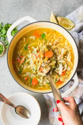 Overhead view of a pot of chicken noodle soup.