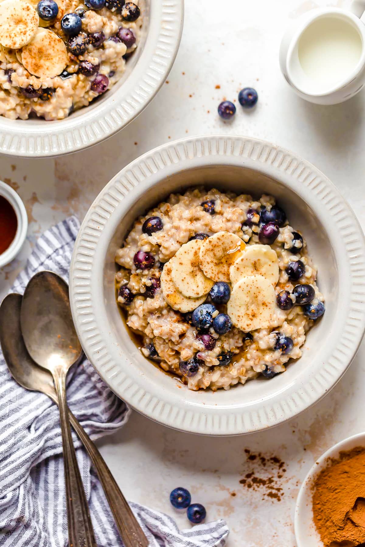 Instant Pot steel cut oats are so much faster than making them on the stove! Learn how to cook steel cut oats for a warm, hearty breakfast. Overhead view of a bowl of steel cut oats with blueberries and bananas