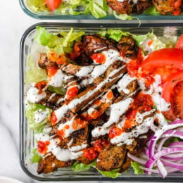 Halal Food Cart inspired chicken served over a big salad of lettuce and tomatoes drizzled with a yummy white sauce.