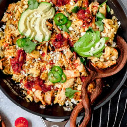 Overhead view of Tex Mex migas in skillet with sliced avocado