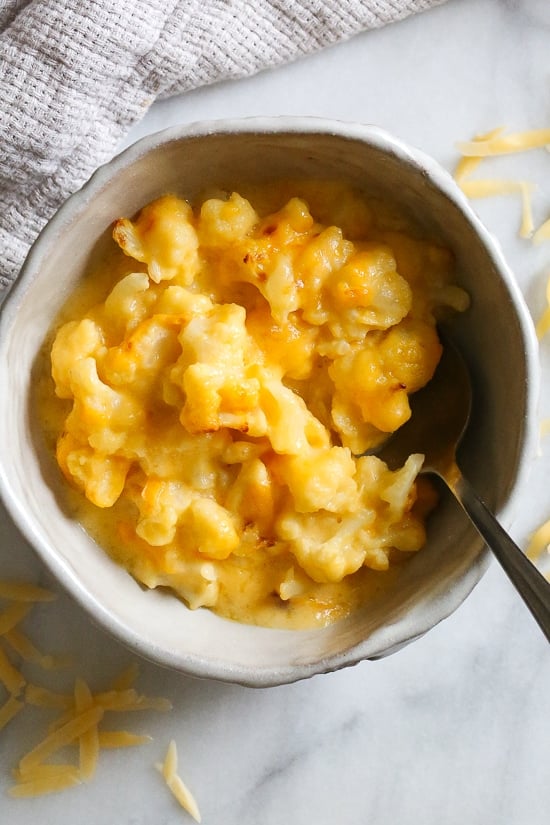 Cheesy cauliflower mac and cheese is perfect when you're craving macaroni and cheese, without the pasta. Each serving is loaded with veggies! Overhead view of a bowl of cauliflower mac and cheese with a spoon.