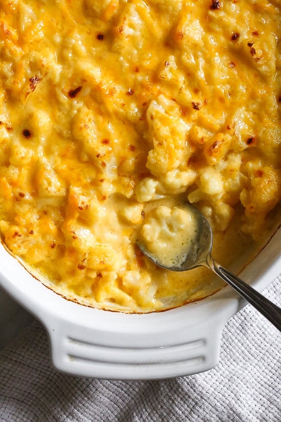 Cheesy cauliflower mac and cheese is perfect when you're craving macaroni and cheese, without the pasta. Each serving is loaded with veggies! Overhead view of a baking dish of cauliflower mac and cheese.