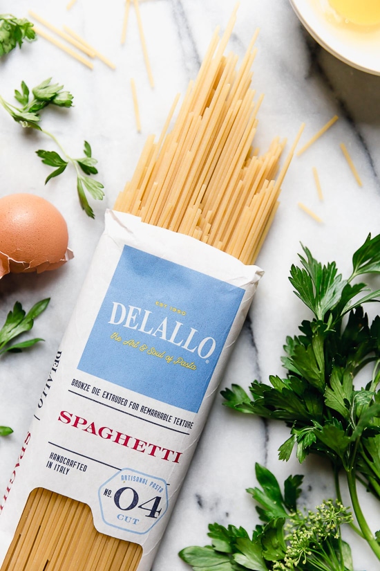 With diced bacon, grated cheese, black pepper, and a poached egg, this Spaghetti Carbonara is simple yet elegant. Delalo spaghetti on a countertop