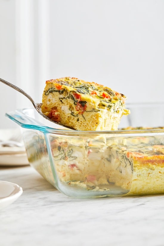 This easy Breakfast Casserole recipe is made with eggs, spinach, tomatoes and Feta cheese and only takes a few minutes to whip up. You can make it ahead of time, so it’s the perfect breakfast egg casserole for Christmas morning or any day!