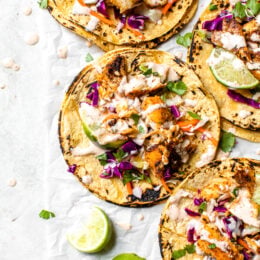 This easy, healthy fish taco recipe is made with cod seasoned with a chili-lime cumin rub topped with slaw – no breading, no frying!