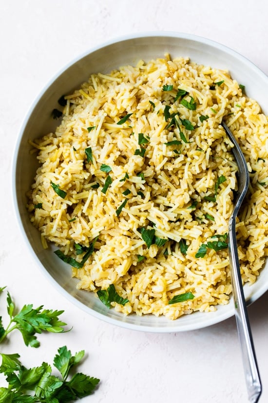 This homemade Rice-a-Roni style rice pilaf is made with toasted pasta, brown rice, and broth for an easy, buttery, family-friendly side dish. Bowl of rice pilaf with fork.