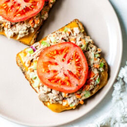 Tuna salad on bread with cheese and tomato