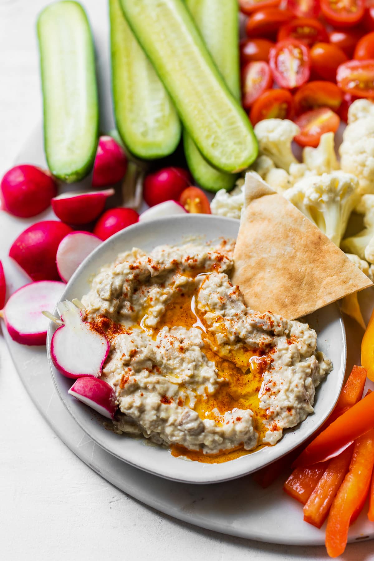 This authentic baba ganoush recipe is smoky, smooth, lemony and garlicky. It's a healthy dip that's easy to make and so delicious! Bowl of baba ganoush topped with olive oil.