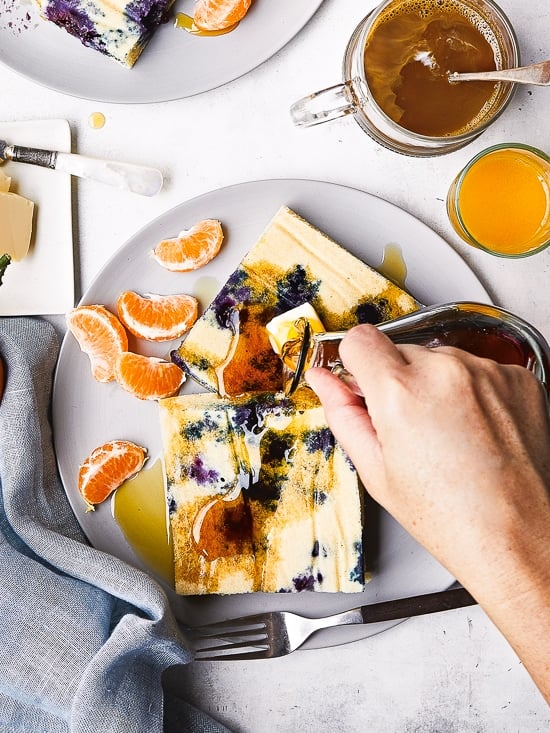 This easy sheet pan pancakes recipe is essentially a giant, fluffy pancake baked in the oven. The most genius way of making pancakes! Lemon Blueberry Buttermilk Sheet Pan Pancakes on a plate with syrup.