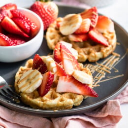 Waffles with strawberries, peanut butter and bananas.