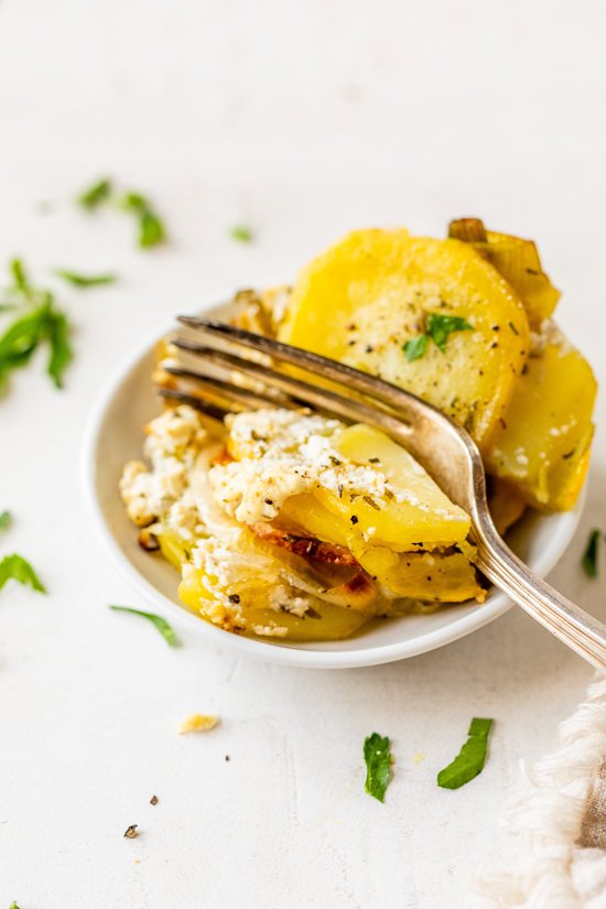 Golden brown Pommes Anna potato cups baked with leeks and herbs in a muffin tin