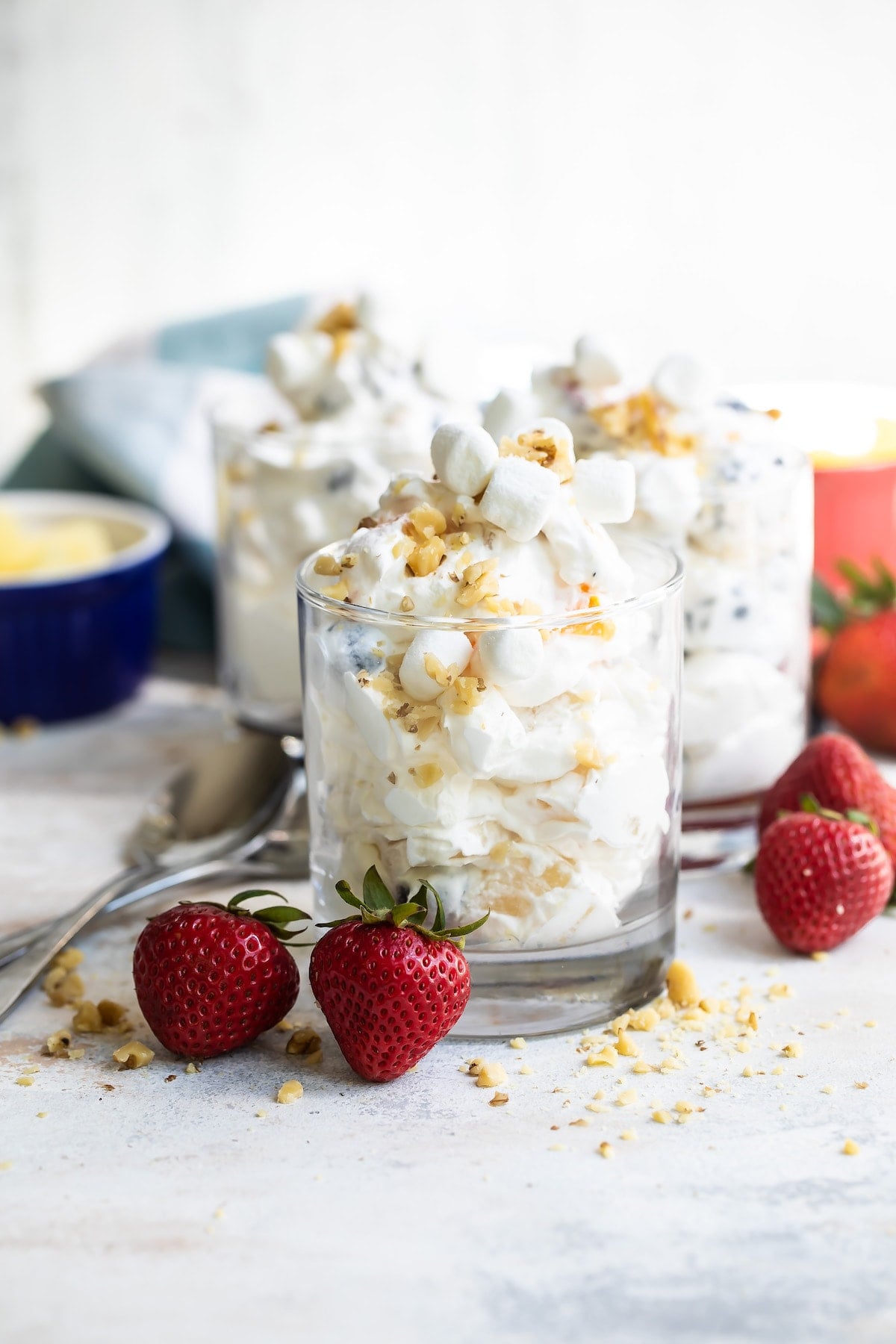 With a variety of fresh fruit, whipped cream, walnuts, and marshmallows, Ambrosia Fruit Salad is ready in minutes. A perfect summer dessert! Ambrosia salad in 3 glass serving containers.