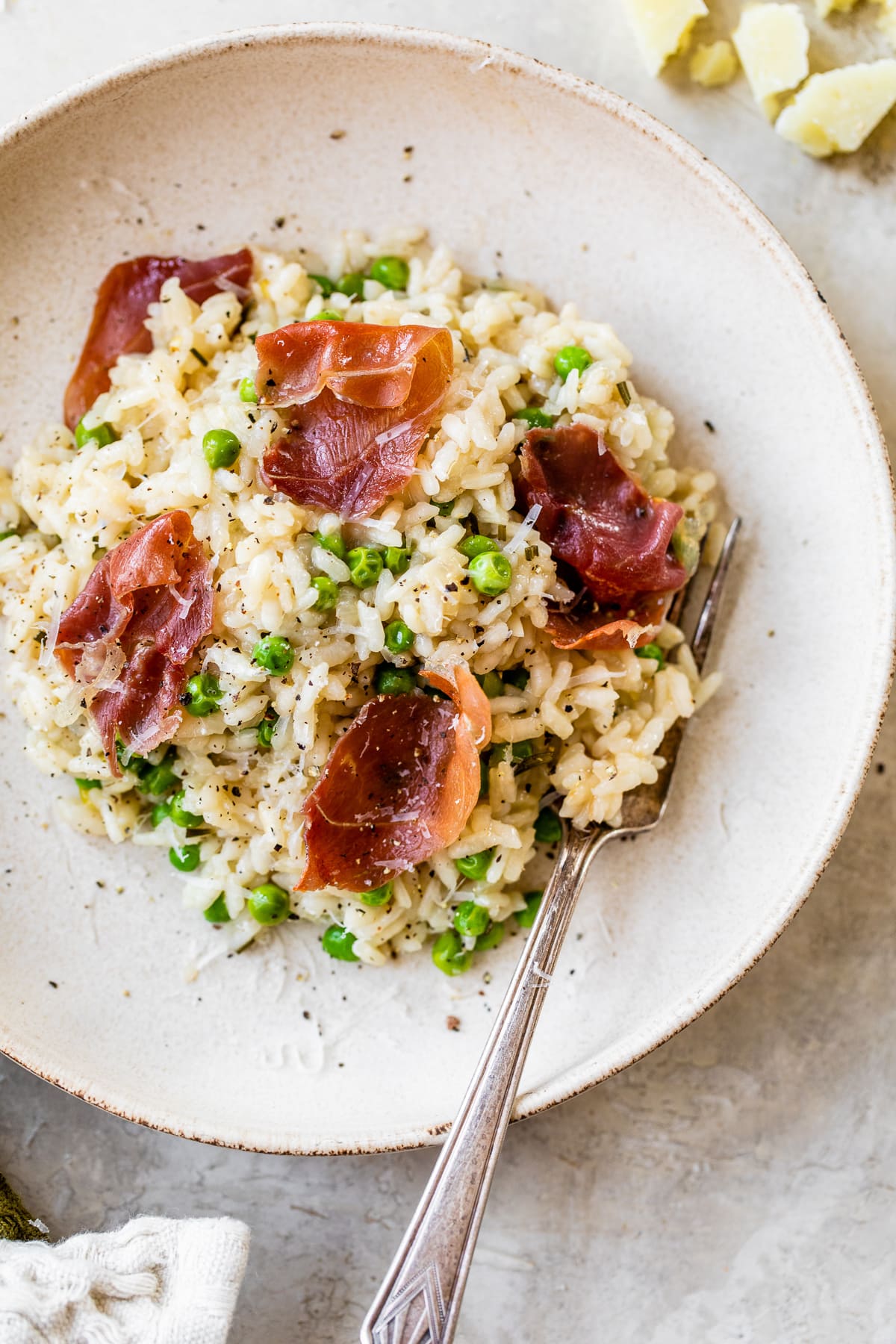 This Instant Pot Risotto recipe is the quickest, easiest way to make risotto. Perfectly creamy every time and it's ready in just 20 minutes. Risotto with prosciutto and peas in a bowl