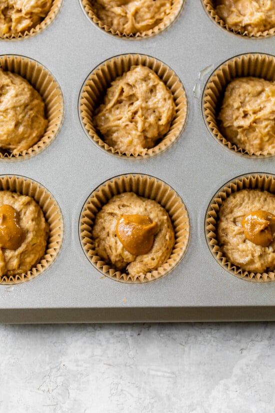 Place the batter in the muffin tin and top with peanut butter.