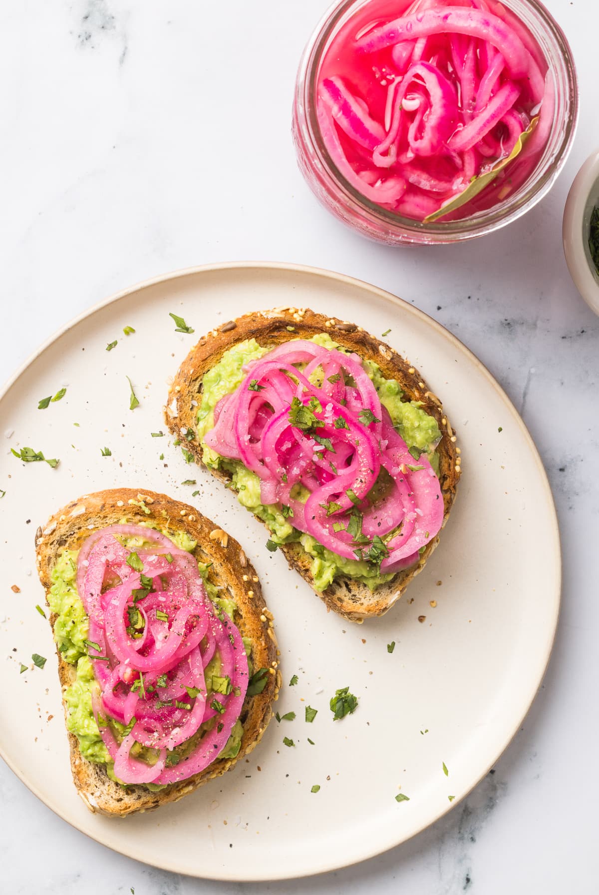 These easy pickled red onions are add a tangy, slightly sweet, and crunchy element to steaks, sandwiches, tacos, burrito bowls and more! pickled red onions on avocado toast