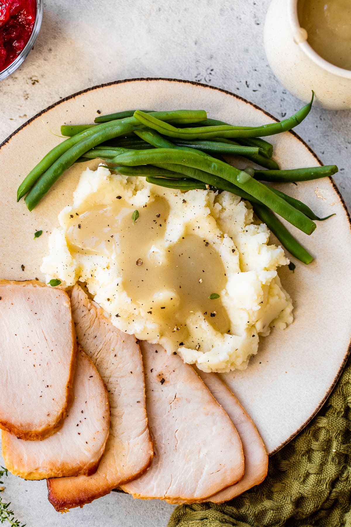 Plate with turkey and Thanksgiving side dishes.