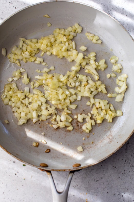 This easy ratatouille recipe is the perfect summer side dish for your favorite roasted chicken, grilled meats, or fish! Onions cooking in a skillet.