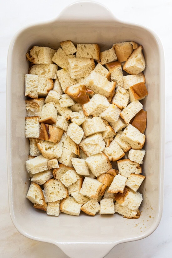 This overnight crème brûlée French toast bake is an easy make-ahead breakfast with fluffy challah, eggy custard, and only 15 minutes of prep! Cubes of challah bread in a casserole dish.