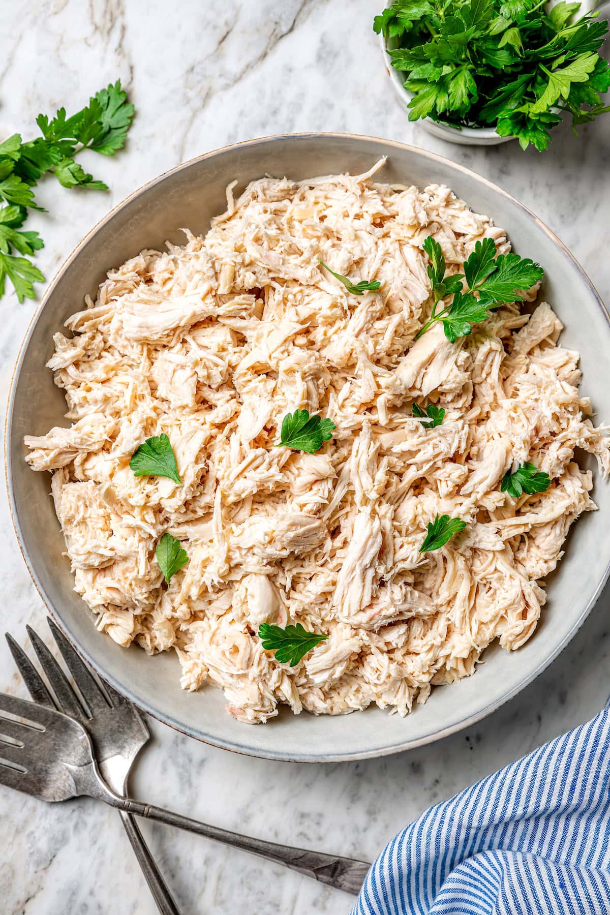 This slow cooker shredded chicken recipe is juicy, tender, and flavorful. It's a hands-off cooking method perfect for meal prep! Crockpot shredded chicken in bowl