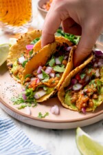 Hand lifting lentil taco from plate